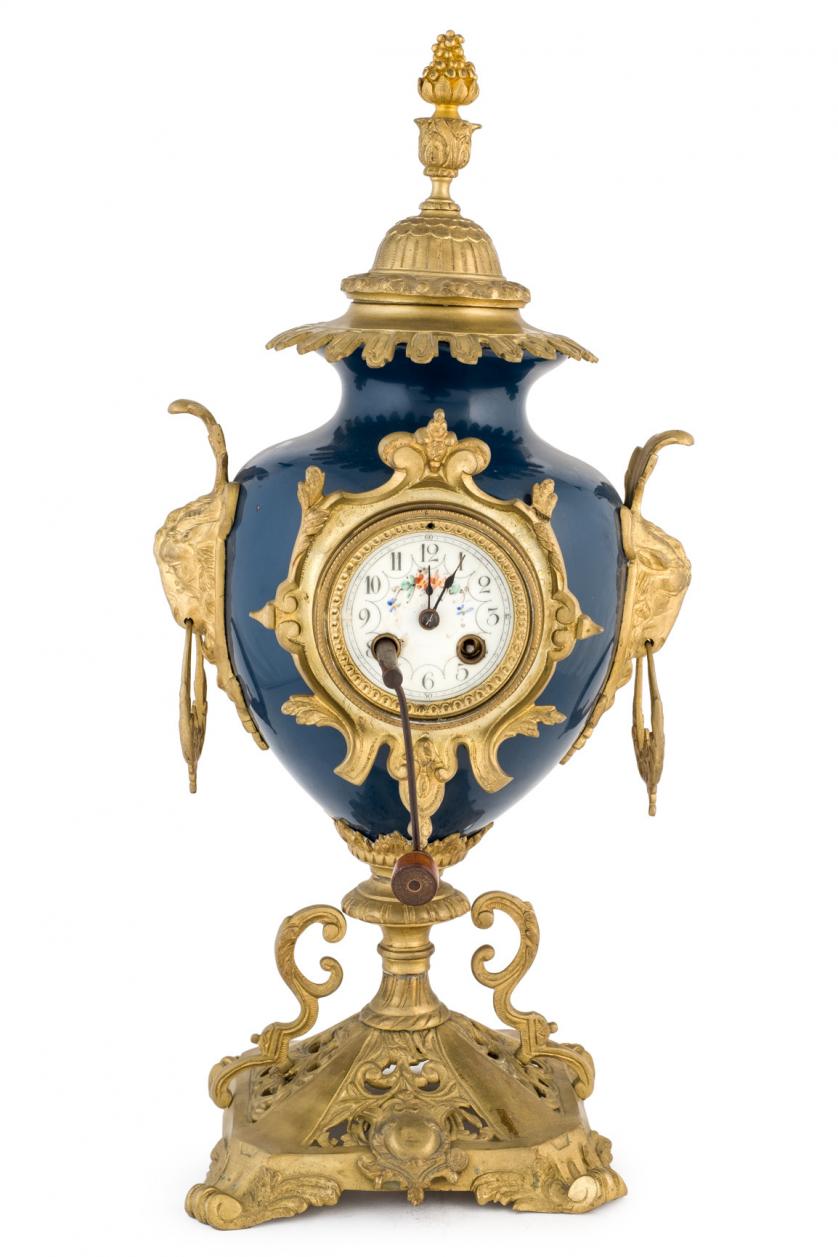 A porcelain and bronze mantel clock. 19th c.