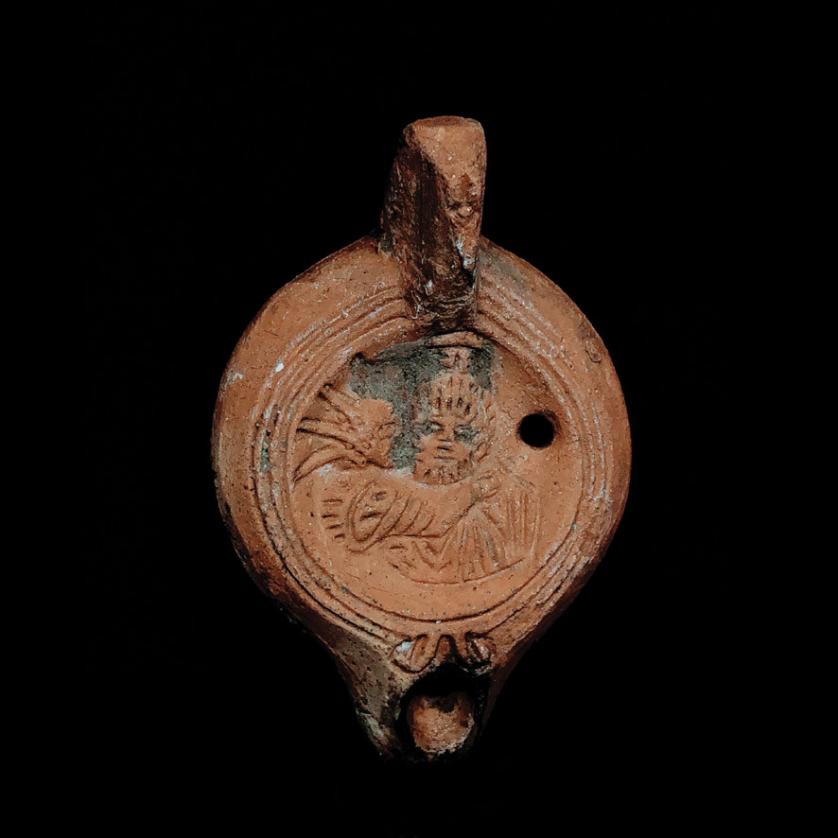 Lucerna de disco romana de terracota con figuras